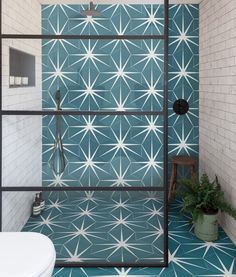 a bathroom with blue and white tiles on the walls, flooring and shower stall