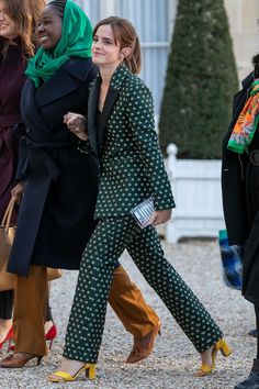 two women are walking down the street with one woman wearing green and white polka dot pants