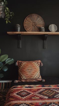 a bed with two pillows on top of it next to a wooden shelf filled with potted plants