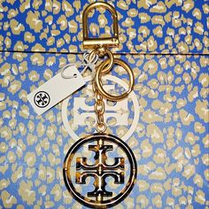 the key chain is attached to an animal print purse with a gold and white logo on it