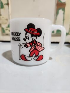 a mickey mouse coffee mug is on the counter