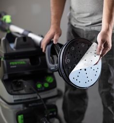 a man is using a steam mop to clean the floor with his hand held on it