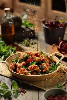 a bowl filled with meat and vegetables on top of a wooden table