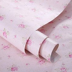 a roll of toilet paper sitting on top of a pink flowered wallpaper covered floor