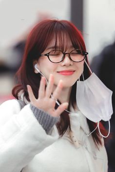 a woman wearing glasses making the vulcan sign with her hand