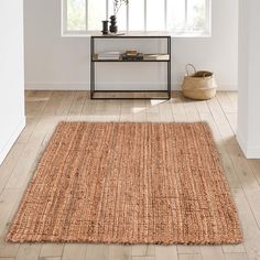 an area rug in the middle of a room with white walls and wooden flooring