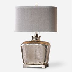 a silver table lamp with a grey shade on it and a white light in the middle