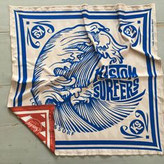 a blue and white bandana with an image of a man on the ocean waves