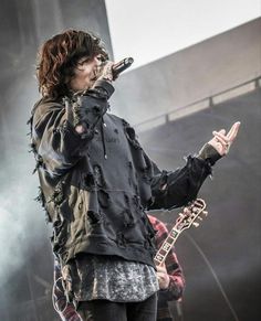 a man standing on top of a stage holding a microphone in front of his face