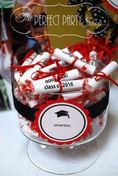 a glass bowl filled with red and white candies next to a sign that says the perfect party show