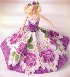 the doll is wearing a purple and white dress with flowers on it's skirt