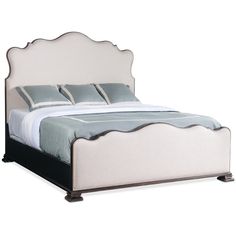 a bed with a white headboard and blue pillows on it's foot board