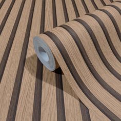 a roll of wood with black and white stripes on the wall next to an area rug