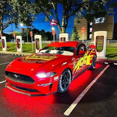 a red sports car parked in front of a gas station