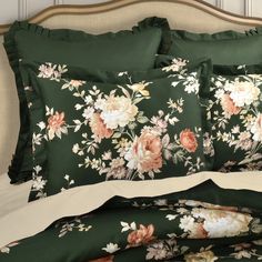 an image of a bed with flowers on the sheets and pillow cases that are green