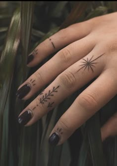 a woman's hand with tattoos on it and an arrow tattoo on the middle finger