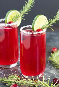 two glasses filled with cranberry margaritas and garnished with fresh rosemary