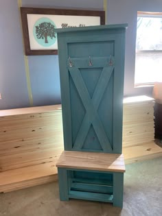 a blue wooden bench sitting in front of a window