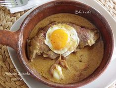 a brown bowl filled with food on top of a white plate