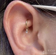 a woman's ear with a single diamond in it