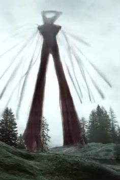 an abstract image of a person standing on top of a hill with trees in the background