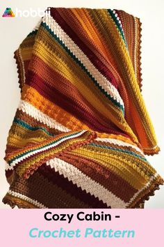 a crocheted blanket with the words cozy cabin written on it