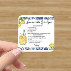 a person holding up a business card with lemonade