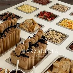 many trays of food are arranged on a table