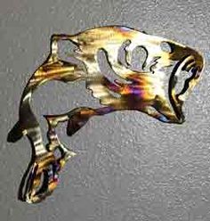 a metal fish sculpture hanging from the side of a wall