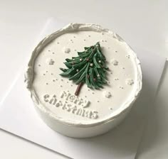 a white cake decorated with a christmas tree