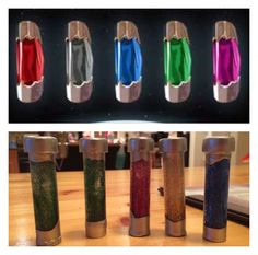 four different colored lighters sitting on top of a wooden table next to each other