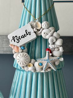 a blue vase filled with seashells and a sign that says beach on it