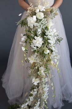 a woman in a wedding dress holding a bouquet of flowers