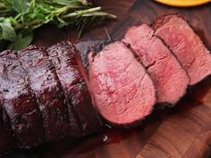 sliced meat sitting on top of a wooden cutting board