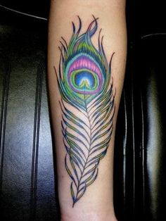 a colorful peacock feather tattoo on the leg