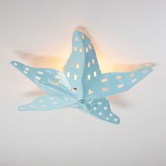 a blue paper bird with white squares on it's wings