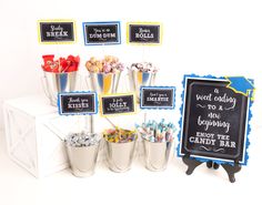 an assortment of candy in buckets with chalkboard signs on the wall behind them