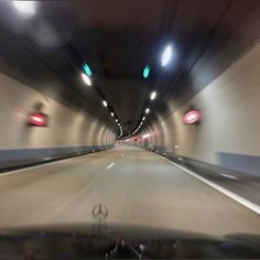 a car driving through a tunnel with lights on