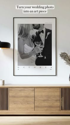 a wedding photo hanging on the wall next to a sideboard in a living room