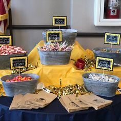 a table topped with buckets filled with candy