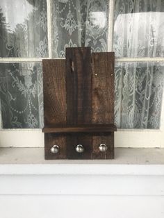 a wooden clock sitting on top of a window sill