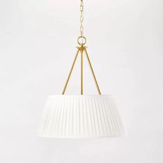 a white lamp hanging from a gold chain