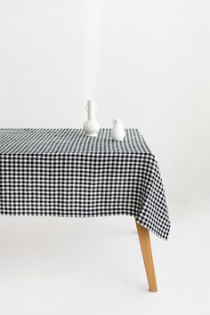 a black and white checkered tablecloth with two small vases on it,