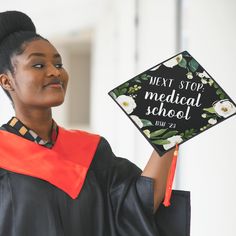 a woman holding up a graduation cap that says god is within her, she will not fall