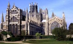 the large cathedral has many spires on it's sides and is surrounded by greenery