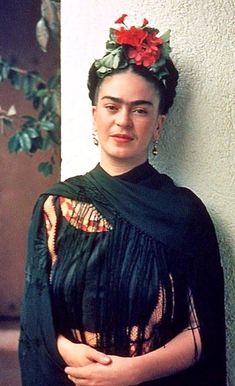 an old photo of a woman with flowers in her hair wearing a black shawl