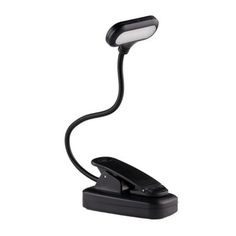 a desk lamp that is on top of a white surface and has a black cord attached to it