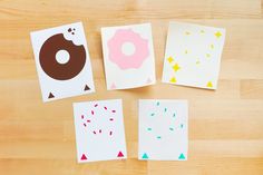 four pieces of paper with different shapes and sizes of doughnuts on them sitting on a wooden surface