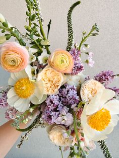 a person holding a bouquet of flowers in their hand