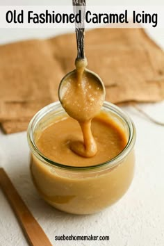 an old fashioned caramel icing in a glass jar with a spoon full of liquid